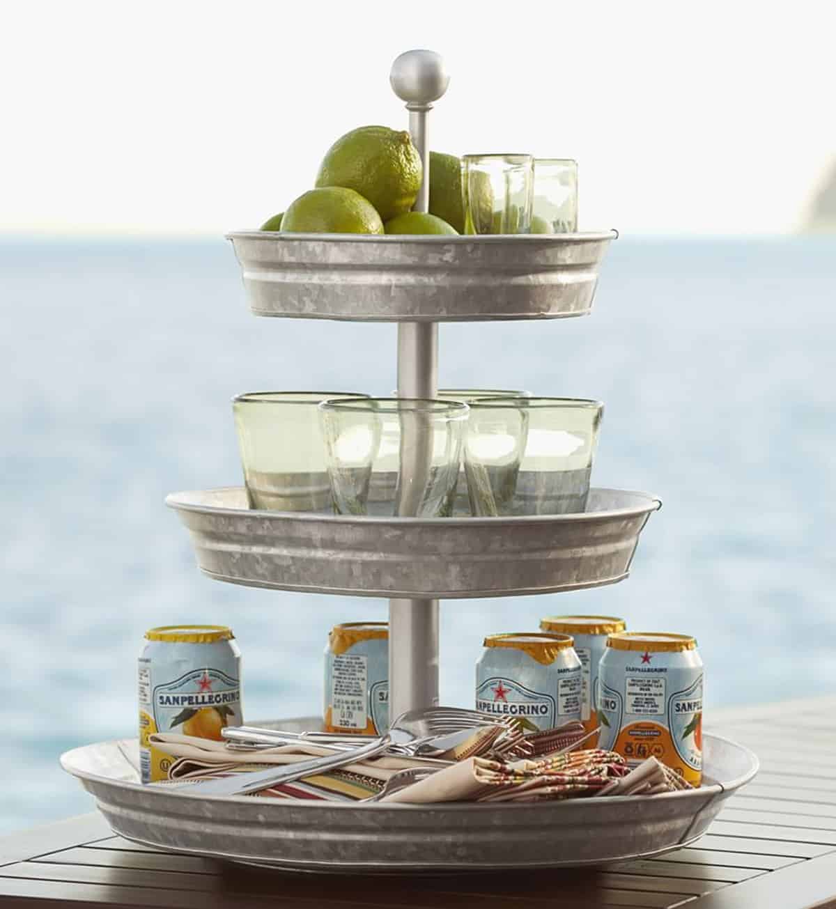 Galvanized serving tray with drinks and glasses and snacks on it for a party.