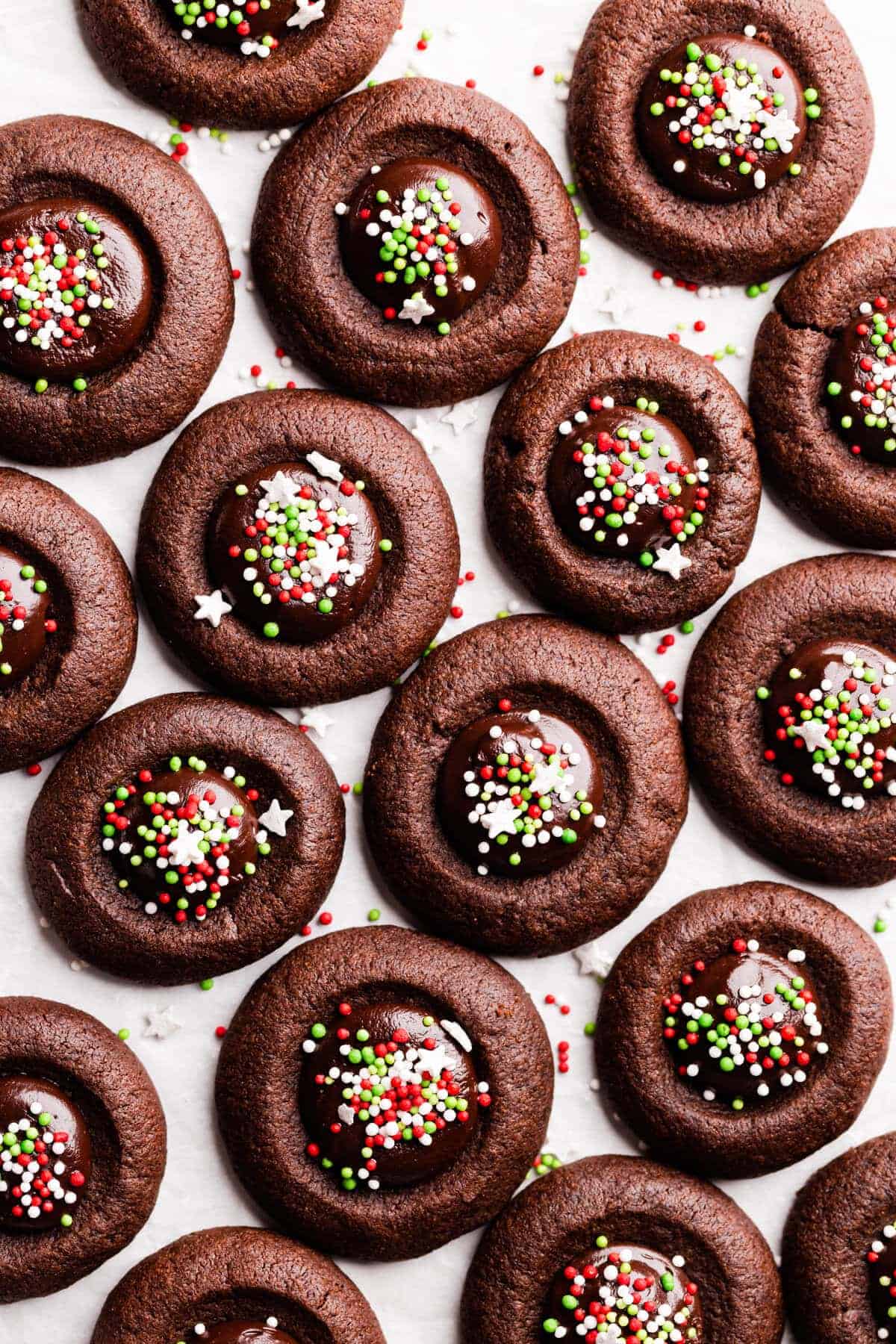 Overhead of chocolate thumbprint cookies with Christmas sprinkles on top.