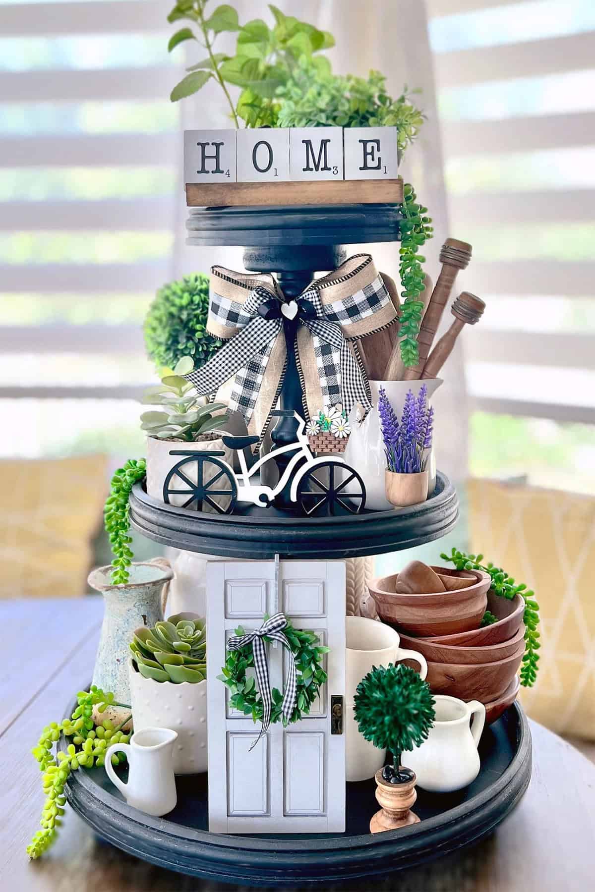 Cottage themed tiered tray with cups and herbs.