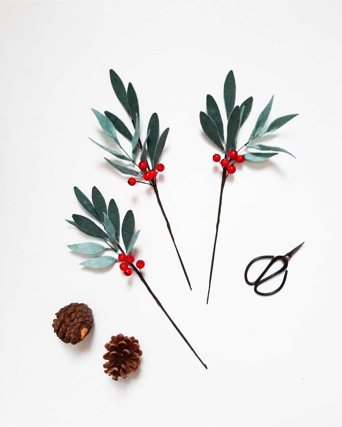 Felt olive leaf branches with red berries on stems.