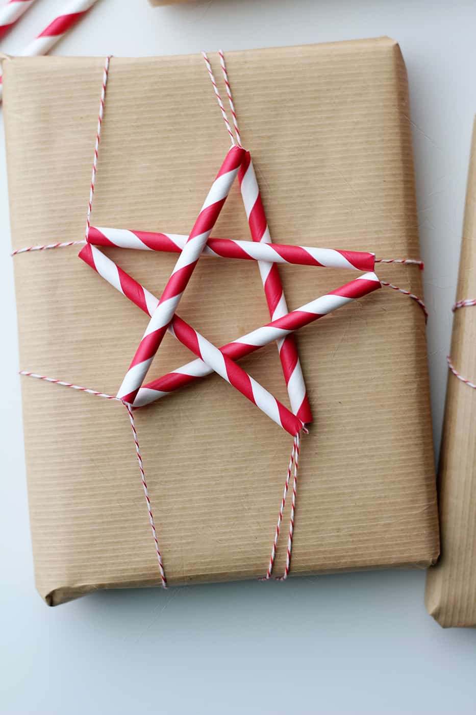 Brown paper package with star made of red and white striped straws.