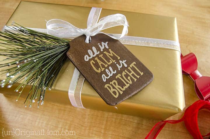 Gold Christmas package with pine sprig and Rustic wooden gift tag.