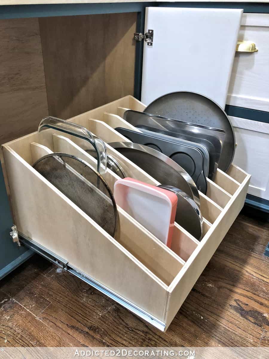 Pull out cabinet slotted drawer DIY filled with baking sheets and glass pans.