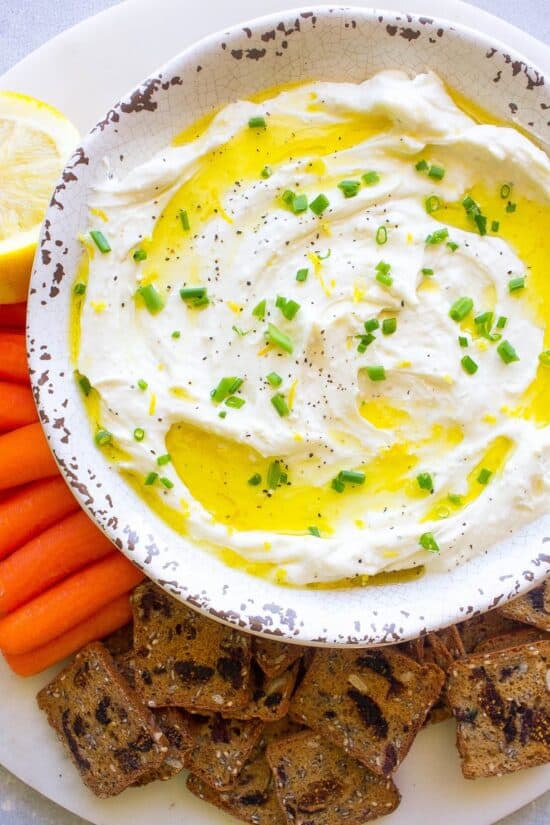 Whipped Feta dip in a bowl with onions sprinkled on top.