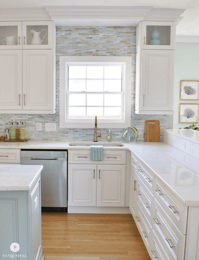 Coastal cottage kitchen with white cabinets and sea glass tile backsplash accent wall.