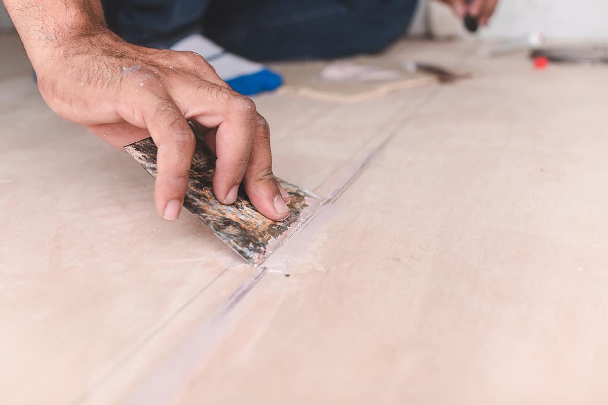 Man filling floor seams and joints.