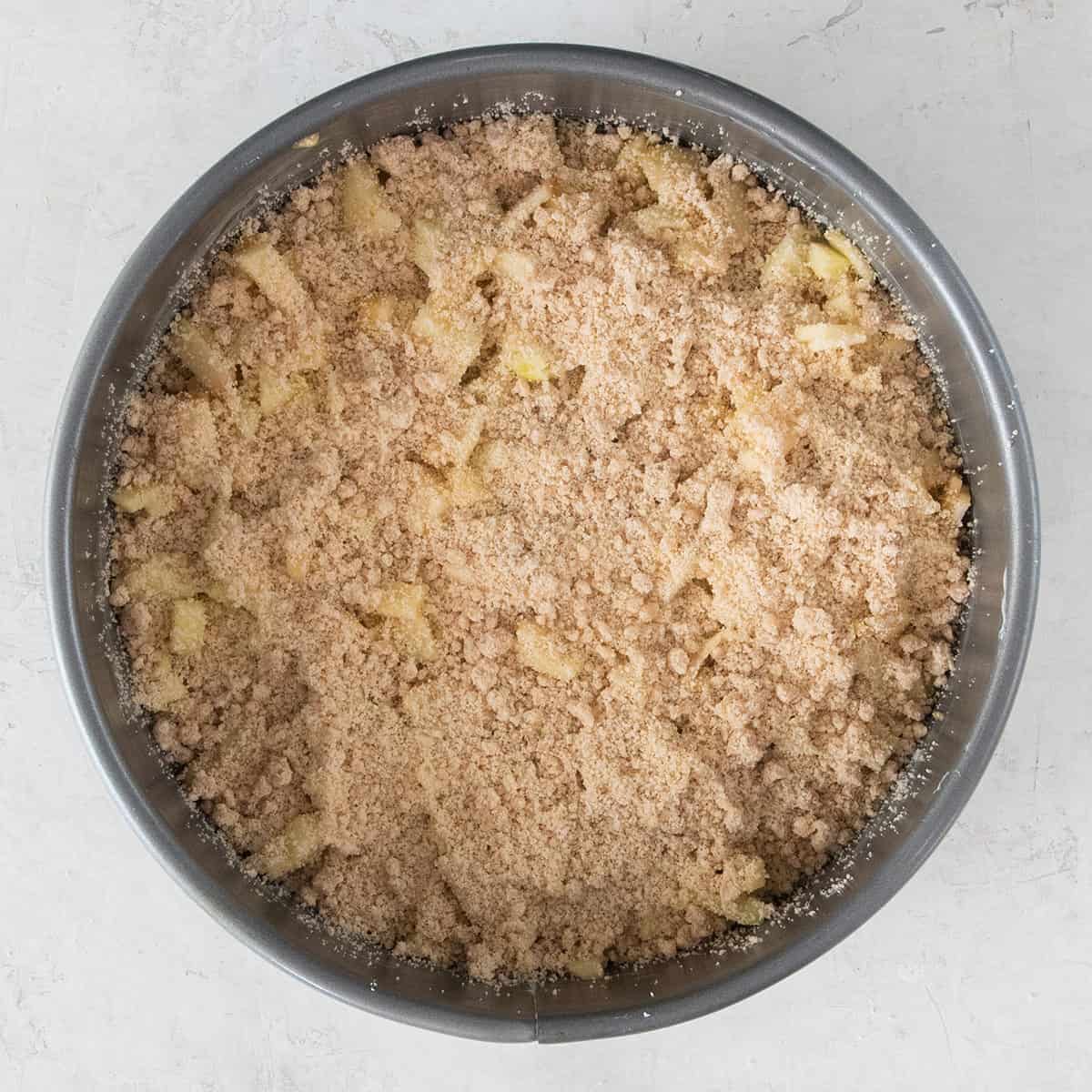 Overhead of apple crumb cake in a pie pan showing the middle layers.