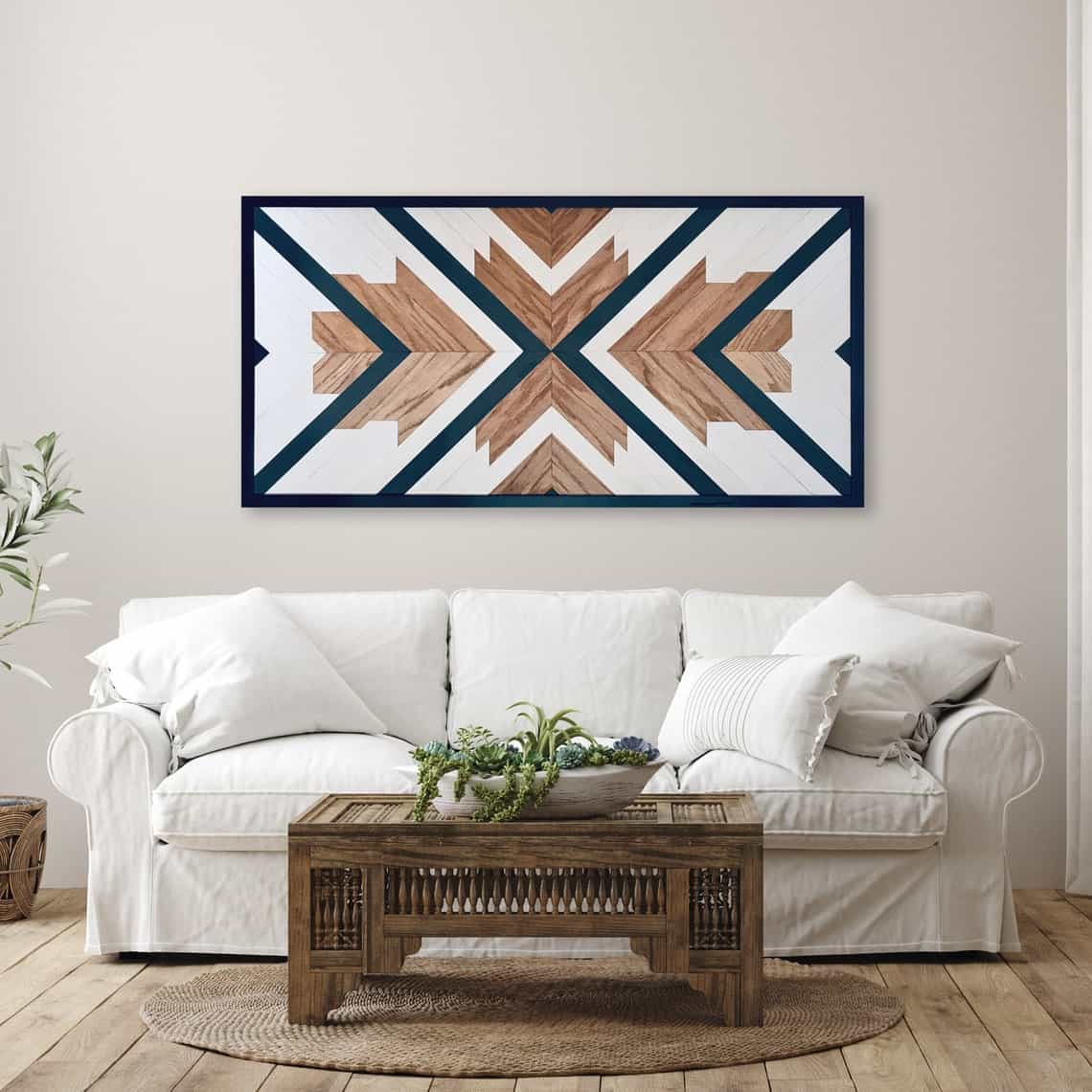 Modern geometric wood wall decoration with navy accents on neutral painted wall in a living room above the couch.