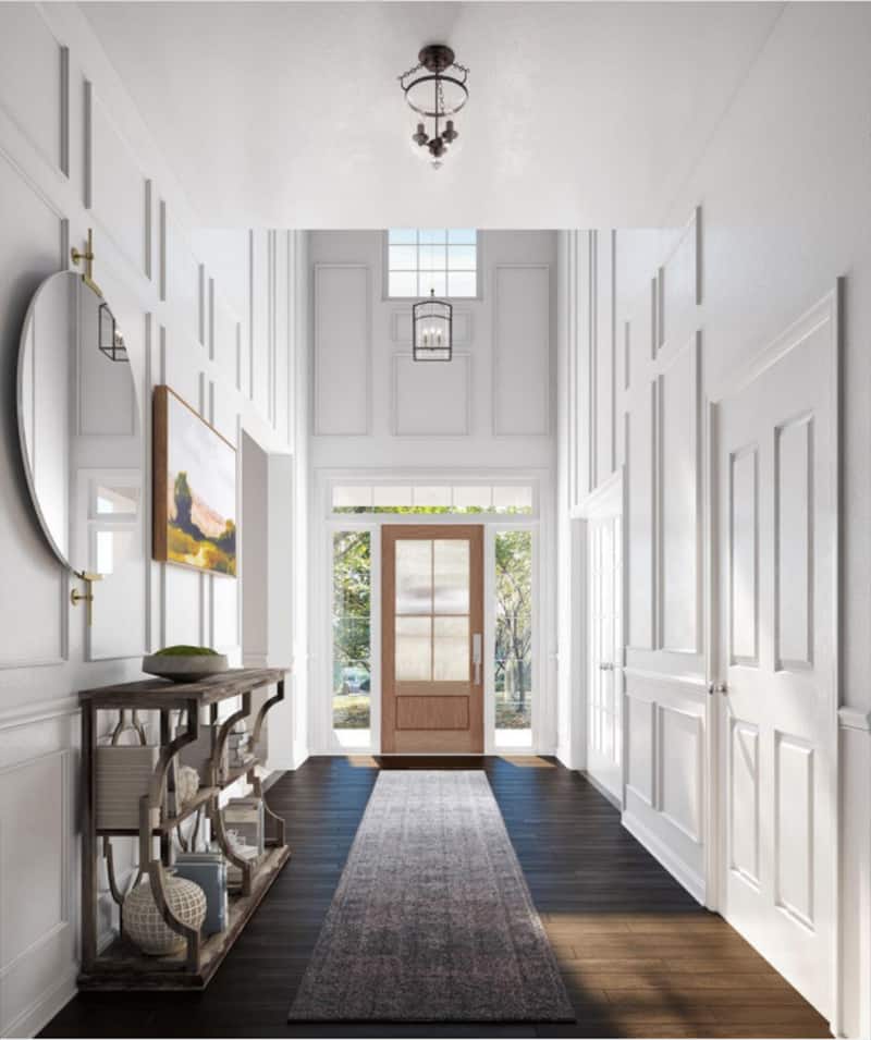Narrow, tall entryway with dark floors and white picture frame molding walls.