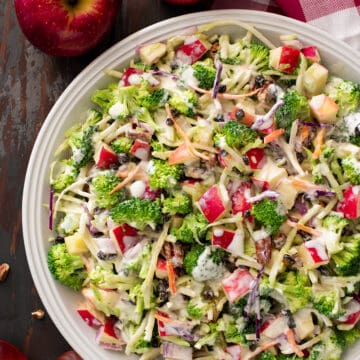 Broccoli apple salad in a bow with two apples on the side.
