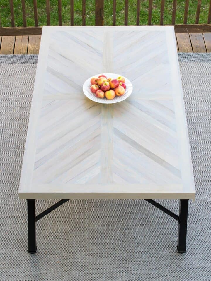 Wood farmhouse table in X cross or herringbone pattern with black legs.