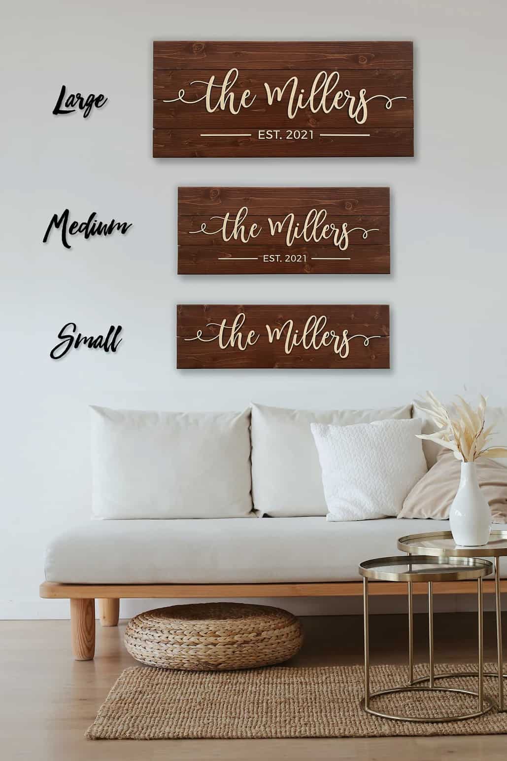 Custom wood address plaques in three different sizes hanging above white pallet style sofa.