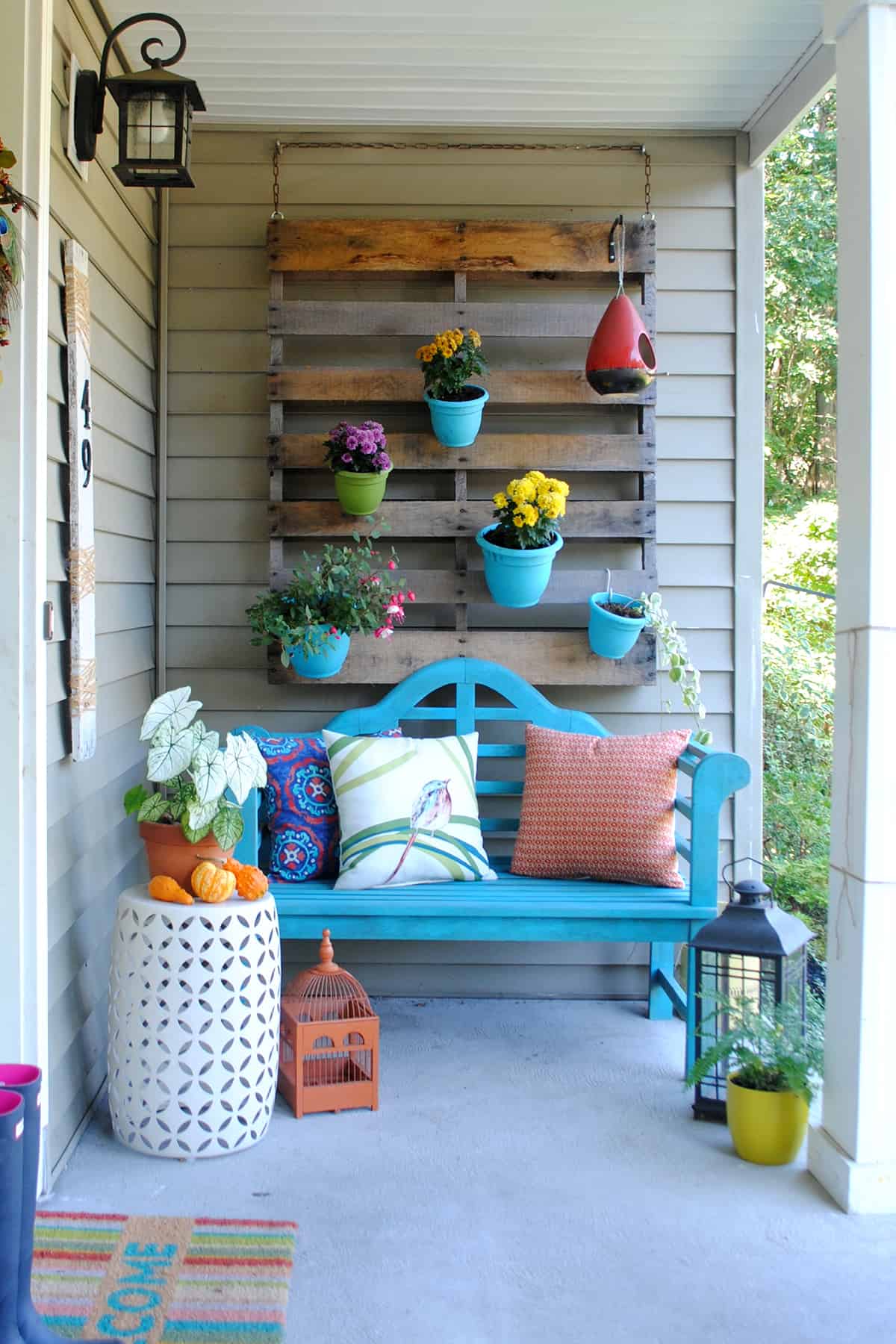 Patio with hanging garden wall made from plants and a wood pallet.