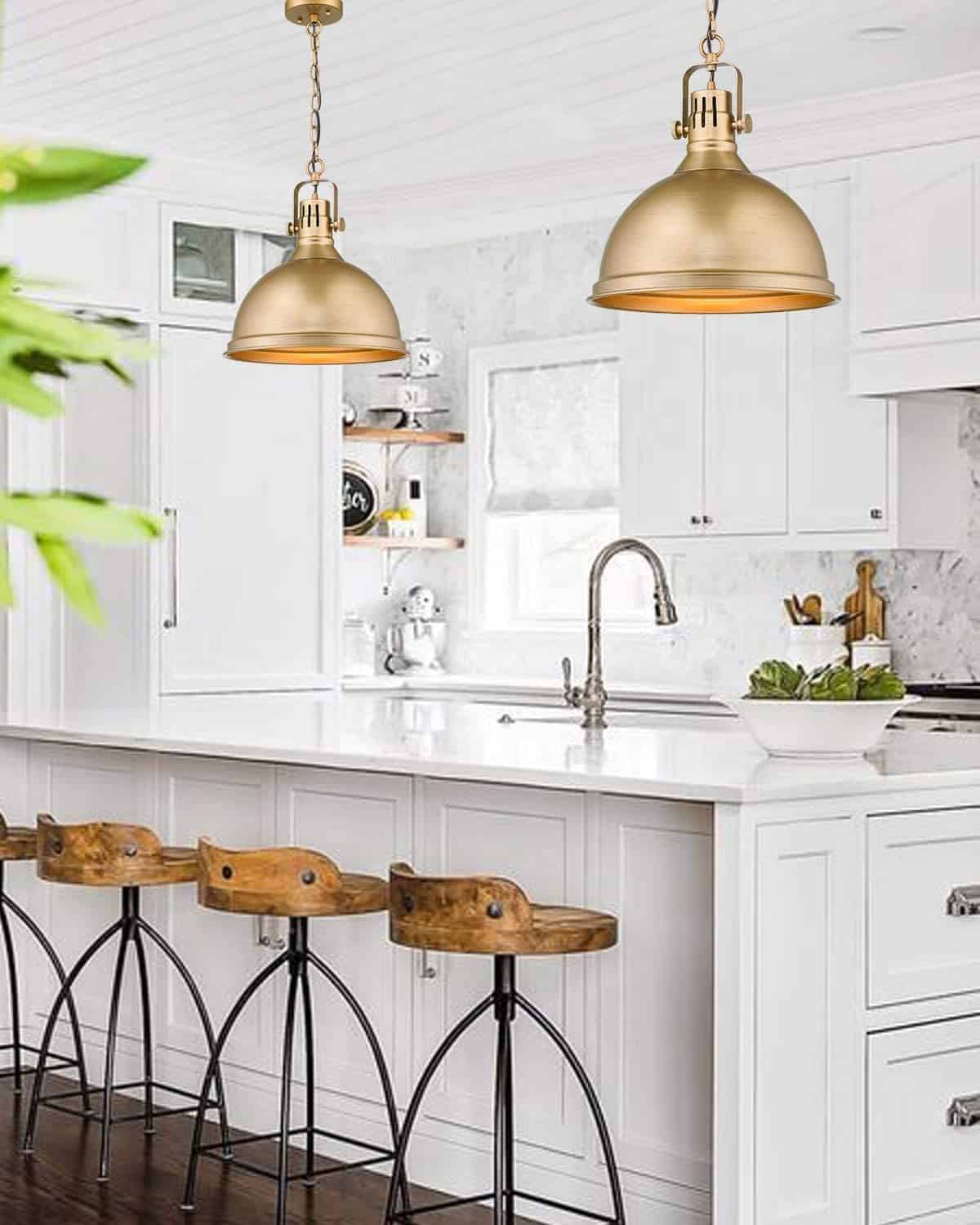 Two large brass bell style pendant lights over white island in modern farmhouse style kitchen.