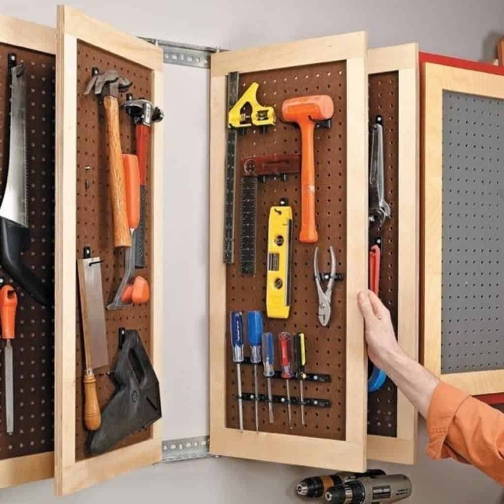 Pegboard made from cabinet frames that flip to hold more tools on the back and fronts.