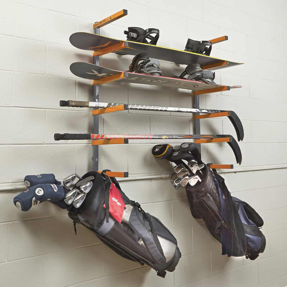Sports equipment organizer rack on a concrete wall for golf and hockey supplies.