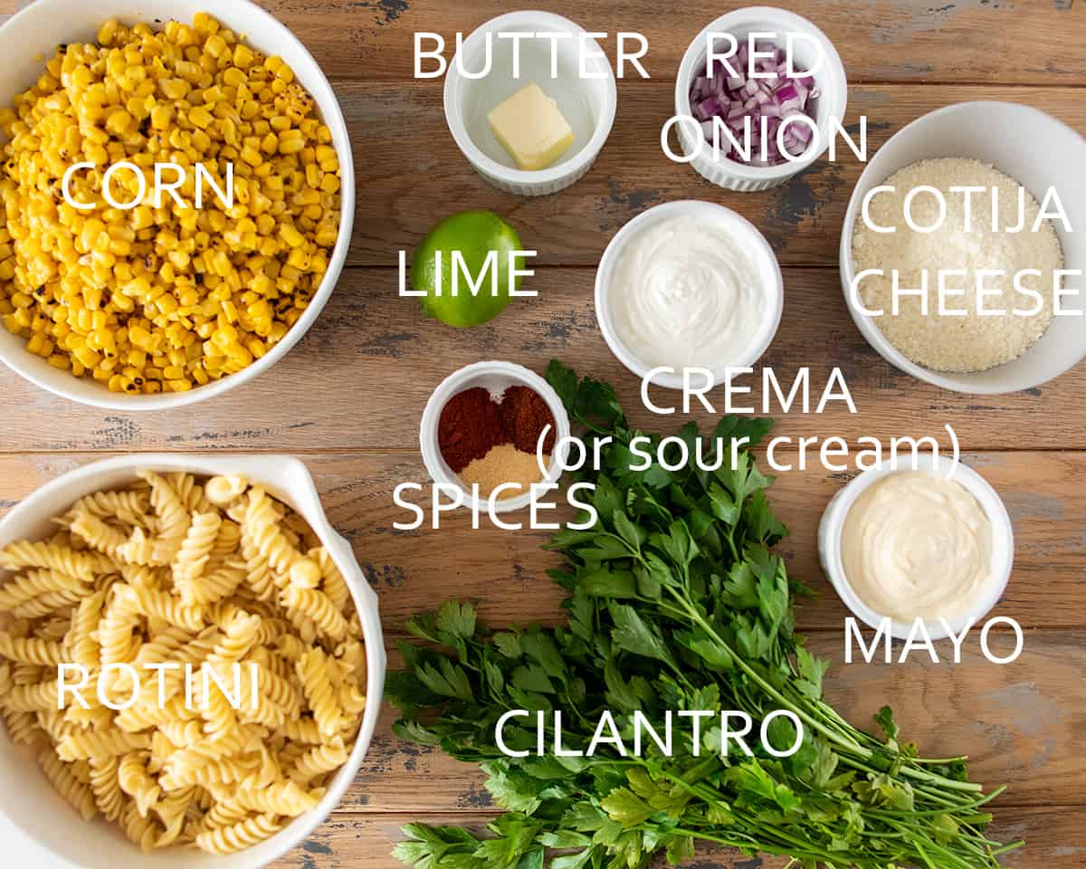 Ingredients to make corn pasta salad laid out on table in bowls with text labels.