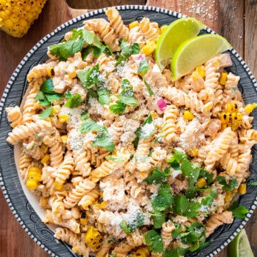 Overhead of mexican street corn pasta salad on a plate with cotija cheese sprinkled around.