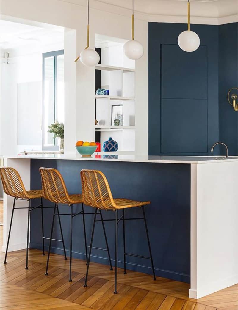 Scandinavian style kitchen features  Stiffkey Blue on island and cabinets. White countertops and minimal accents with pops of color complete the look.