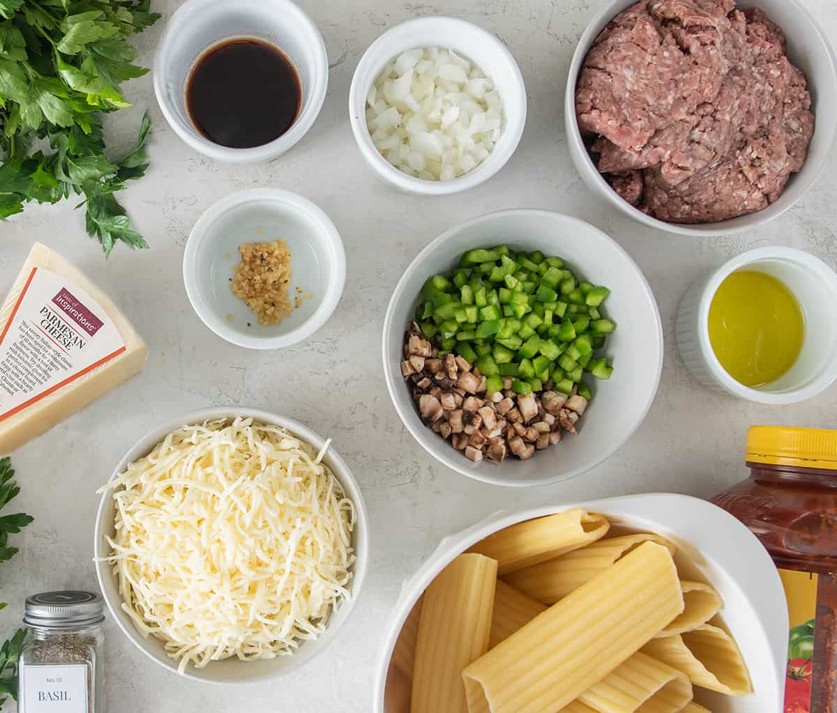 Ingredients to make beef manicotti laid out on table in bowls.