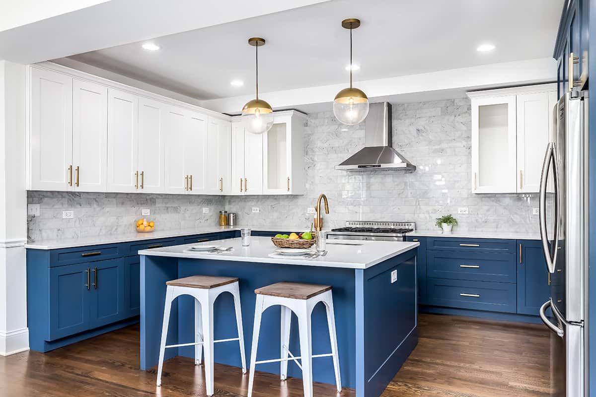 Blue kitchen cabinets in Sherwin Williams Revel with white uppers.