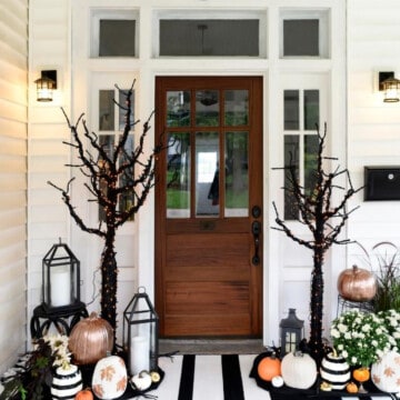 Halloween porch decor with bold black and white décor on a white house.