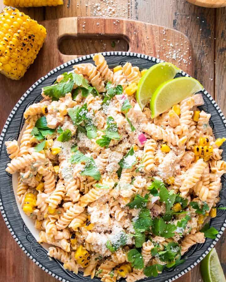 Overhead of mexican street corn pasta salad on a plate with cotija cheese sprinkled around.