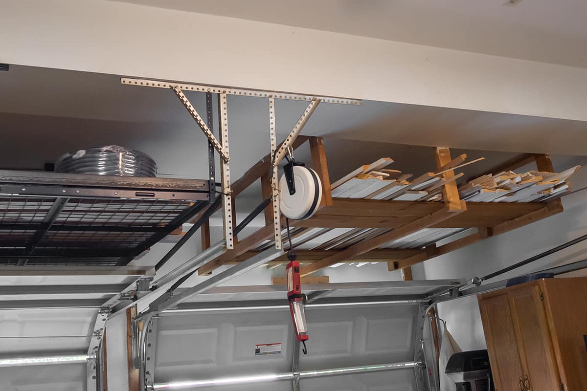 A metal and a DIY overhead storage racks in a garage.