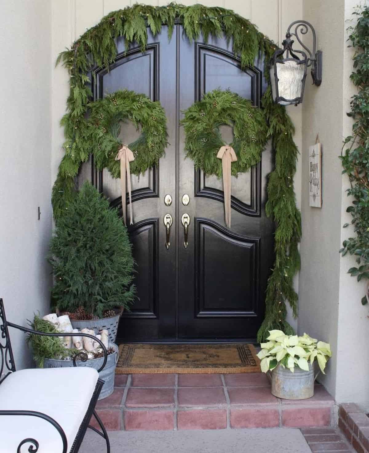 Black front doors Christmas decorations with French country design and white poinsettias.