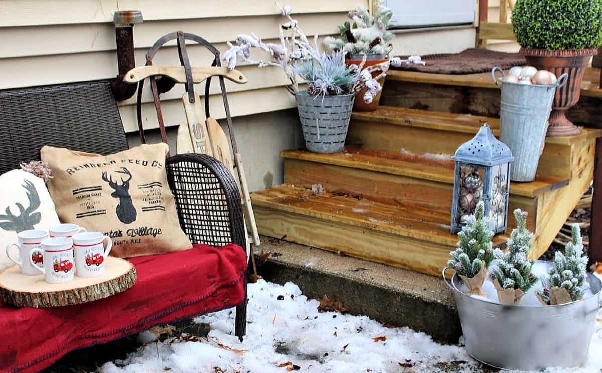 Small entryway Christmas decorated bench with lanterns and small DIY ornaments.