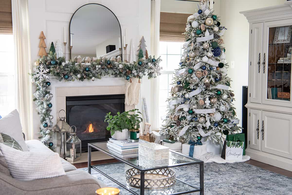 Winter wonderland Christmas decorated living room with fireplace and mantle decorations and white Christmas tree.