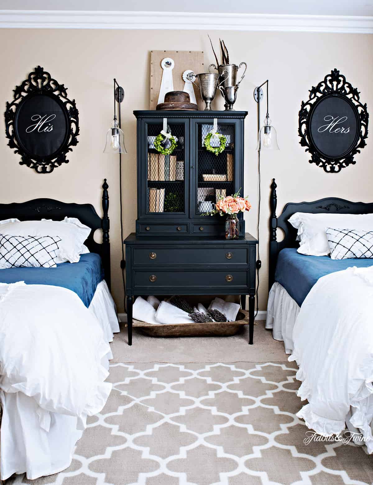 Antique double guest bedroom with black hutch and vintage decorations.