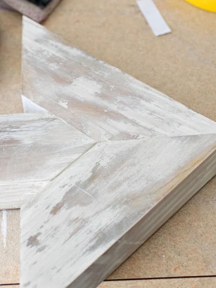 Wood arrow hanging in a gallery wall.