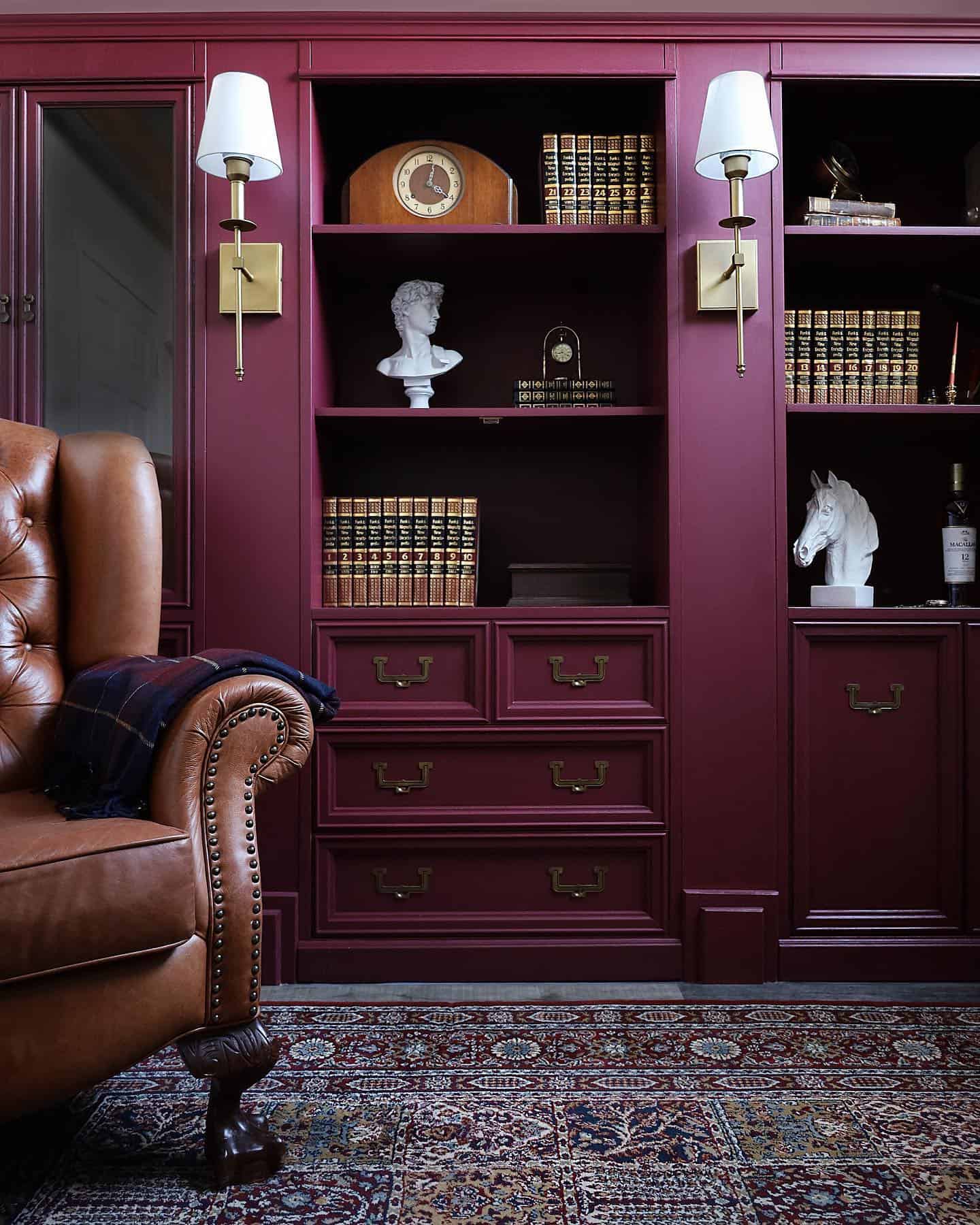 Deep burgundy purple painted antique bookcases in a library.