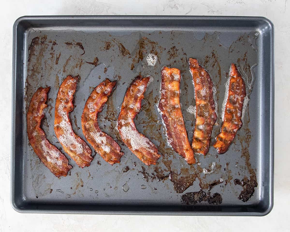 Oven fried bacon on a baking sheet after crisping.