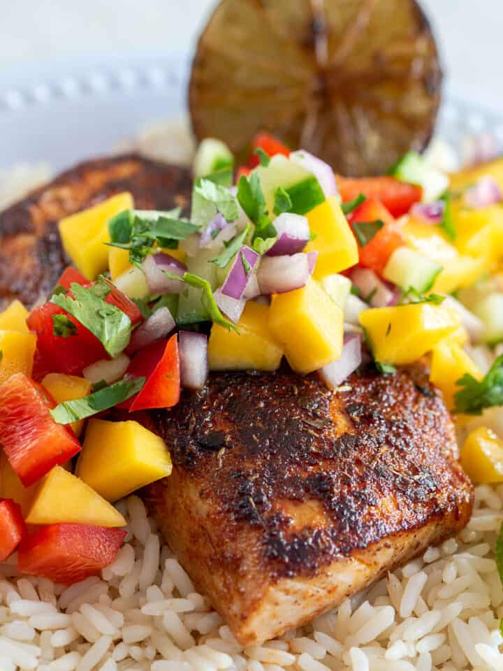 Blackened Mahimahi fish with mango salsa on a bed of rice.