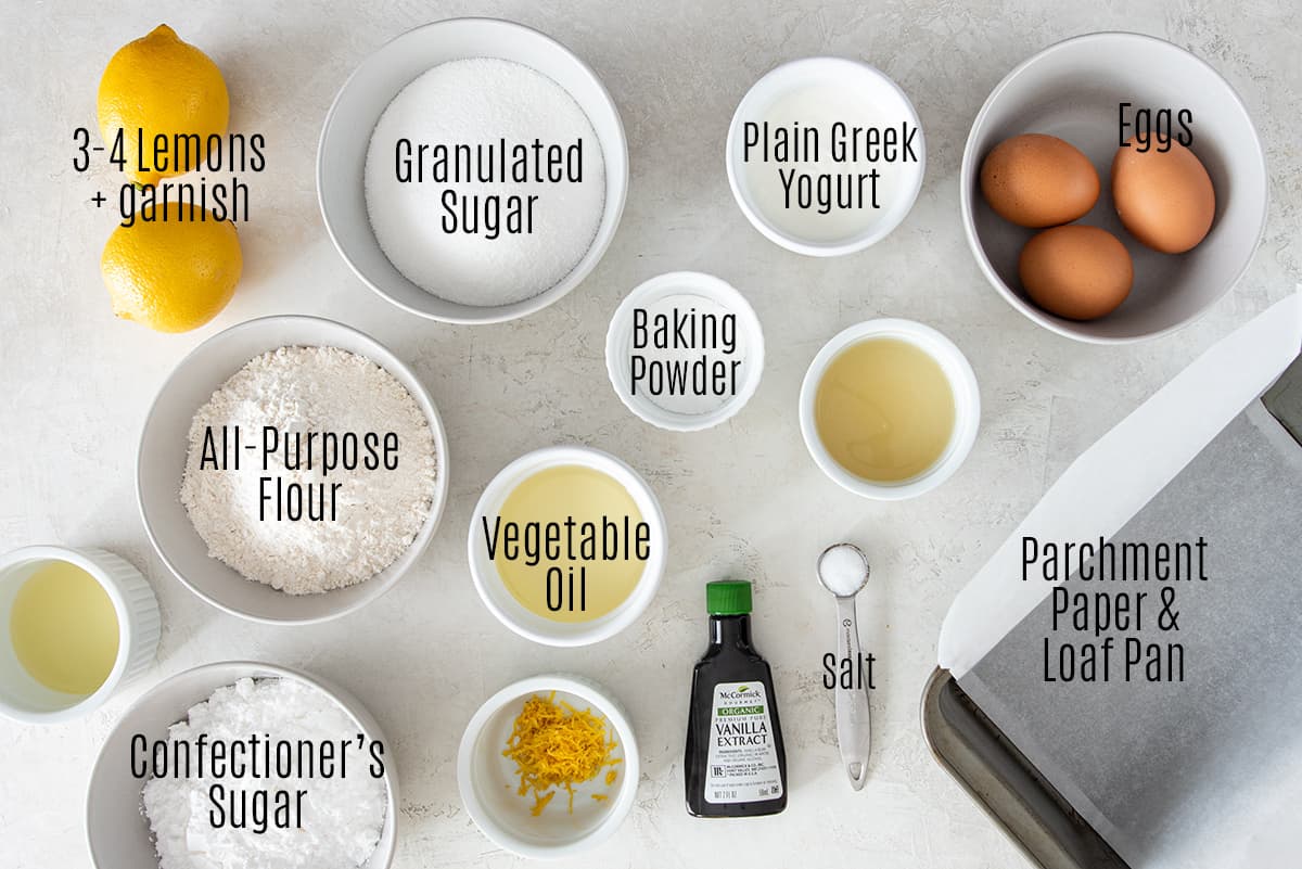 Ingredients for lemon yogurt cake laid out on a table with text labels.