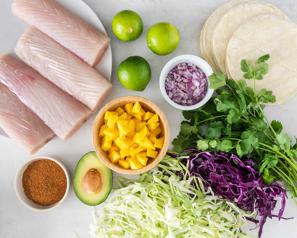 Fish taco ingredients laid out on a table.