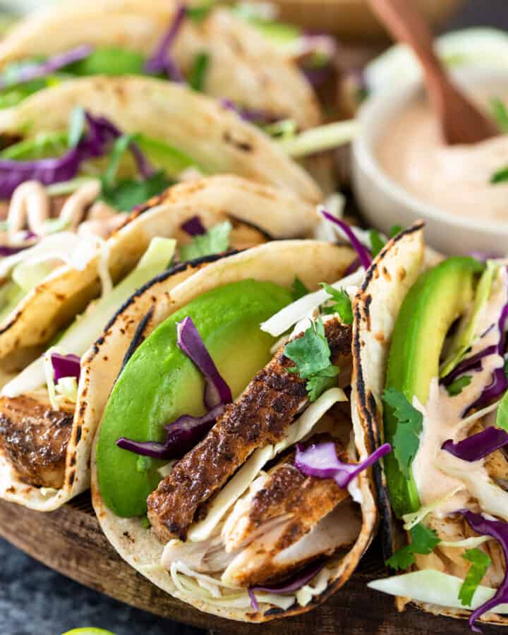 Closeup of fish tacos with avocado and cabbage slaw.