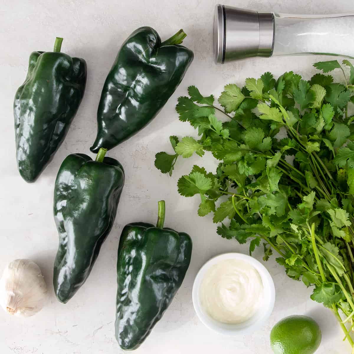 Ingredients for poblano cream sauce laid out on a white background.