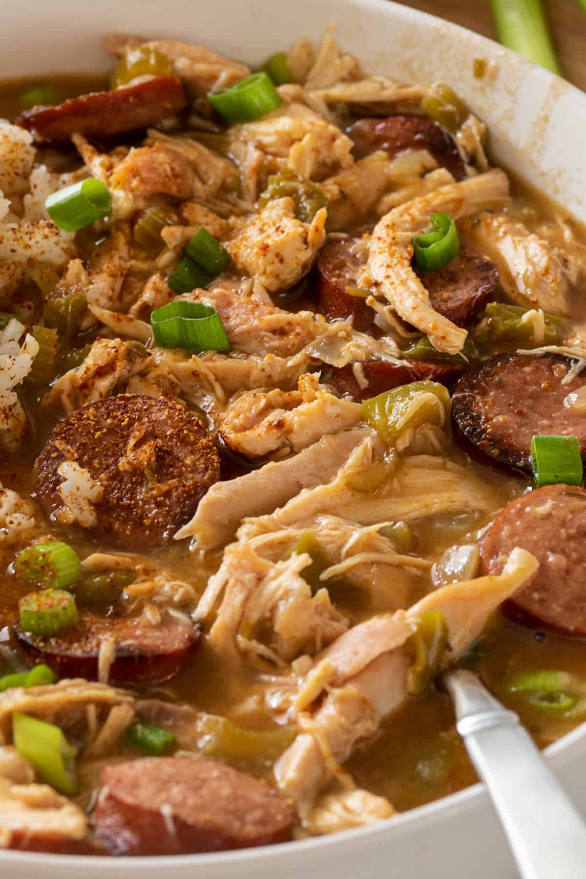 Closeup of chicken and andouille sausage gumbo in a bowl with rice.