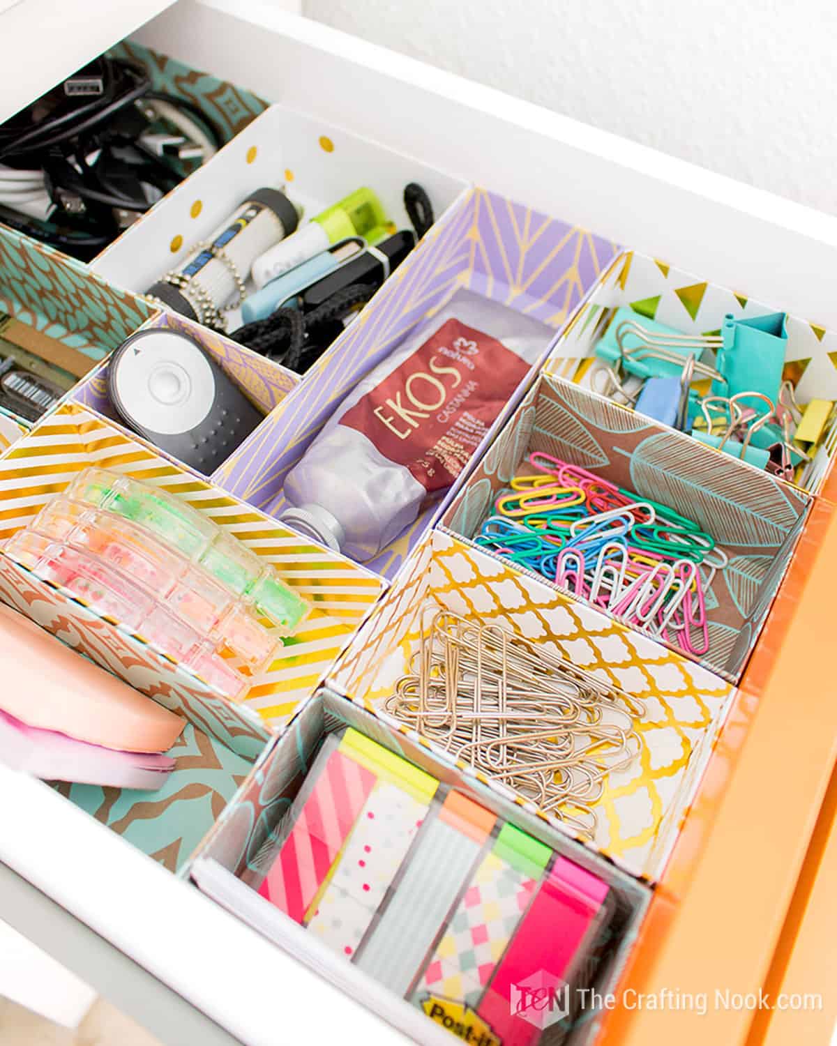 An open drawer with colorful box office supply dividers made out of paper.
