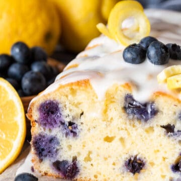 Cross section of lemon blueberry loaf cake with icing to show the texture and blueberries.