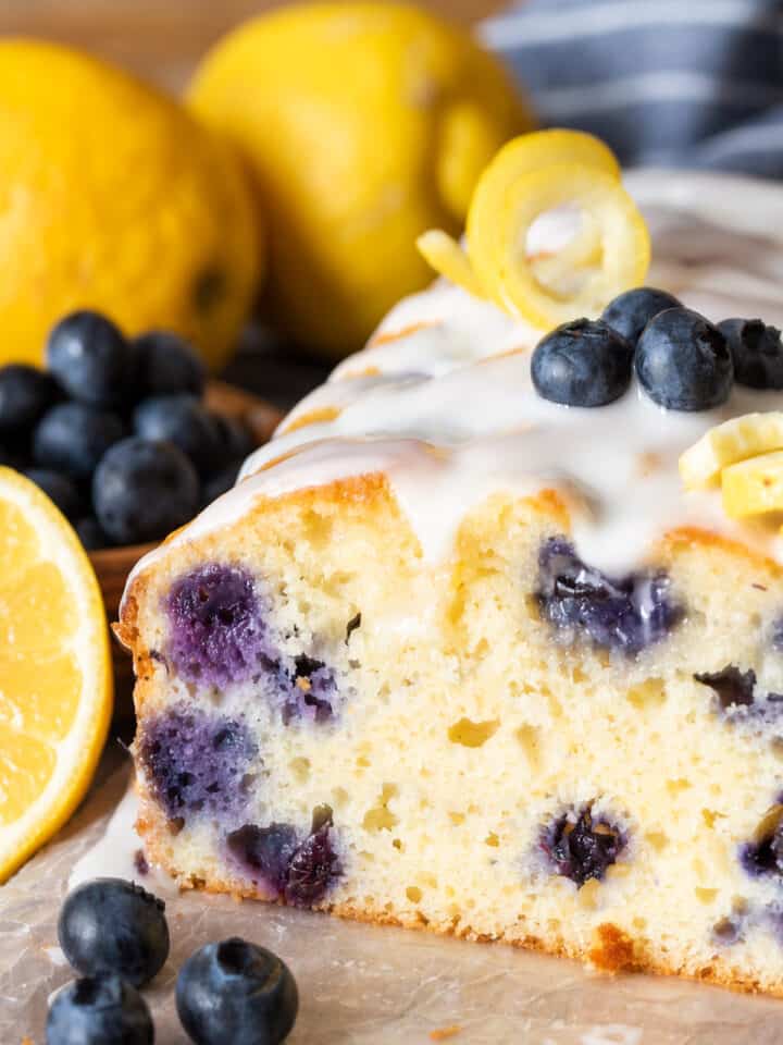 Cross section of lemon blueberry loaf cake with icing to show the texture and blueberries.