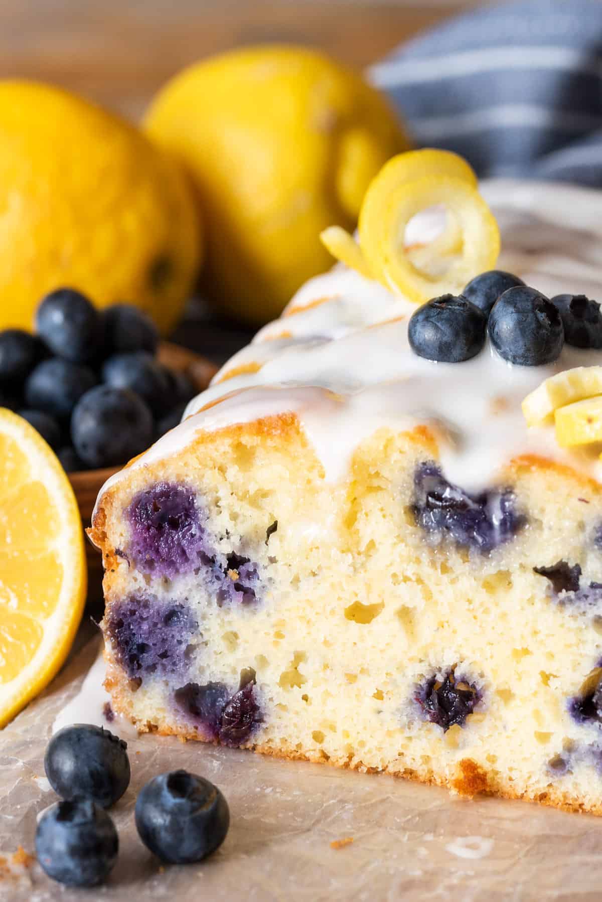 Cross section of lemon blueberry loaf cake with icing to show the texture and blueberries.