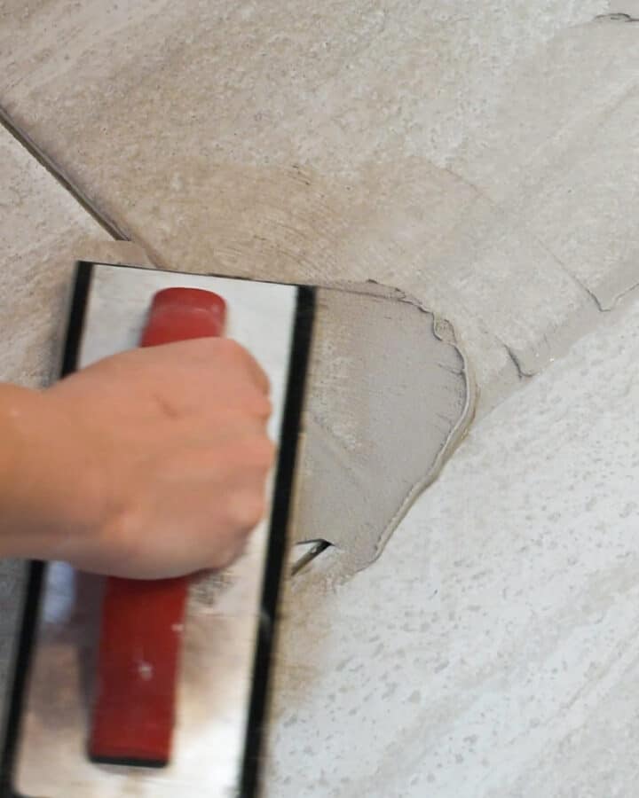 Closeup of someone adding grout to a tile floor
