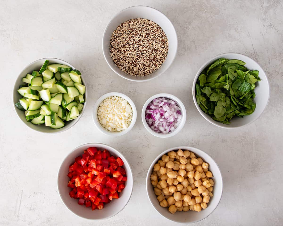 Ingredients for quinoa salad laid out on a light background.