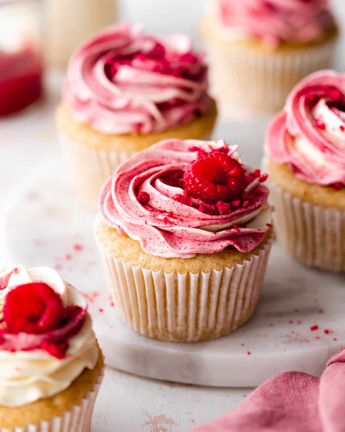 Vegan Raspberry Cupcakes with fresh raspberry garnish.