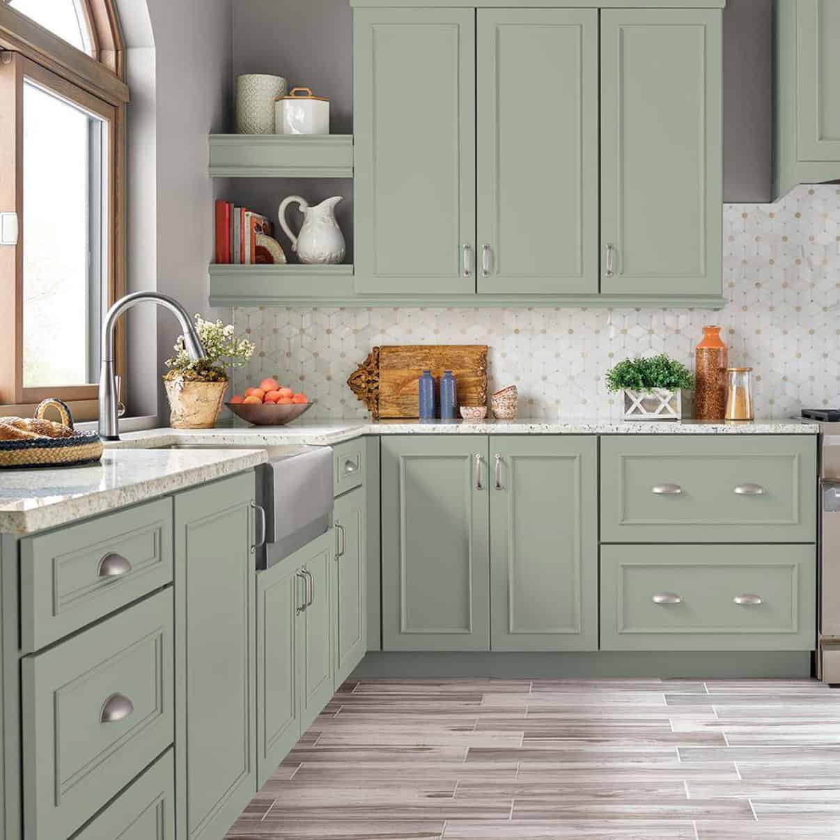 Mint green Kitchen with grey hardwood floors and white backsplash tile.