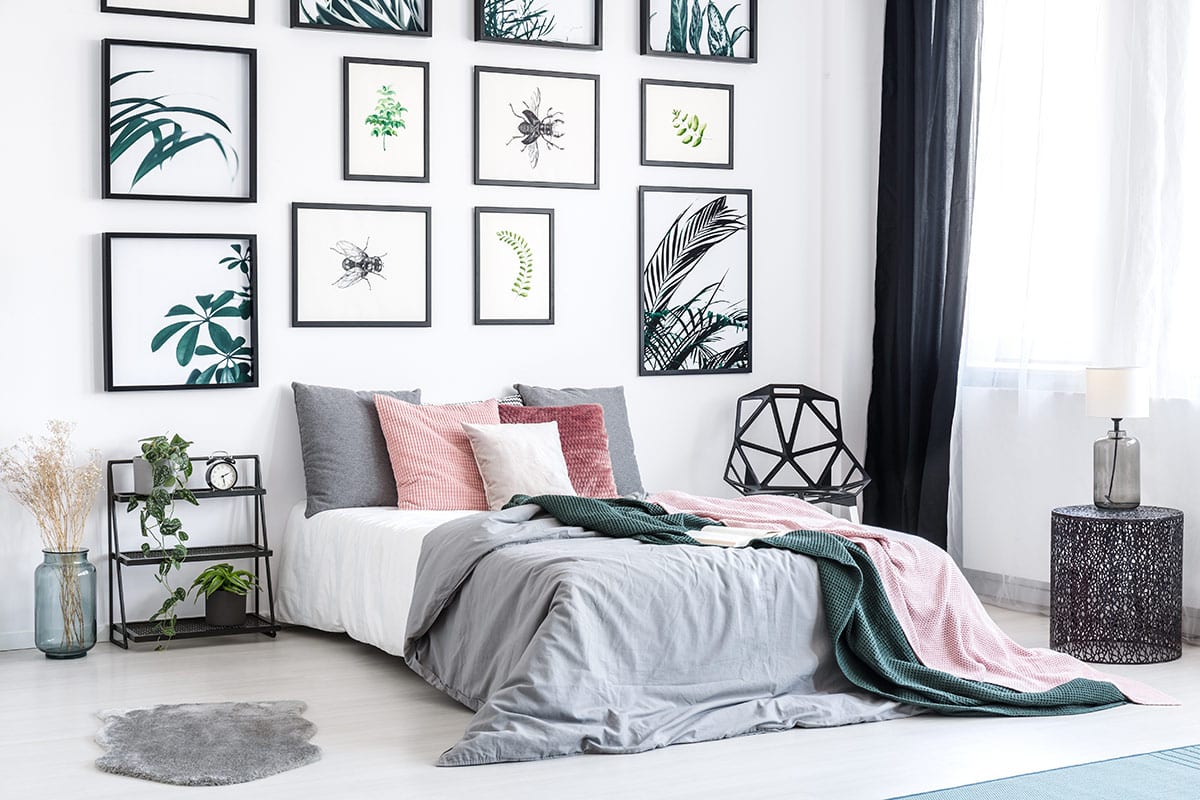 Modern floor to ceiling tropical prints highlight natural elements gallery wall in a bedroom.